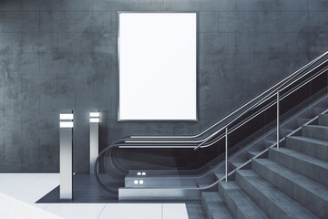 Escalator with empty poster on concrete wall.