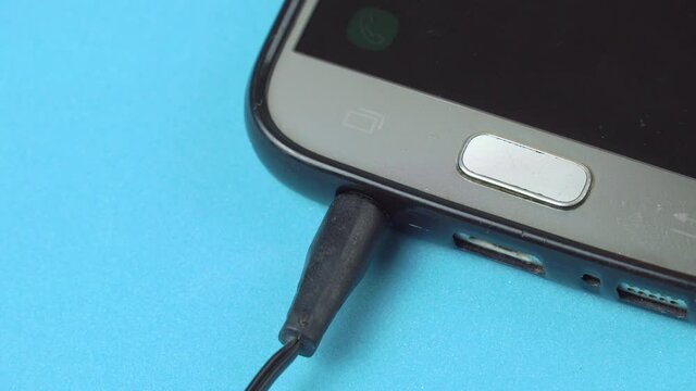 Connecting earphones to smart phone. Extreme closeup of headphone 3.5 mm jack plug.