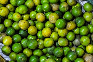 Fullframe background texture of fresh green limes at Bangkapi outdoor fresh market in Bangkok Thailand 