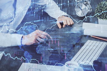 Double exposure of man's hands holding and using a phone and financial graph drawing. Analysis concept.