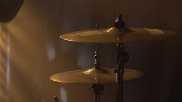 Hands drummer playing on drum kit on stage in a dark studio with smoke and neon lighting. Plates on the drum set close-up. Dynamic neon lighting effects. Performance vocal and musical band.