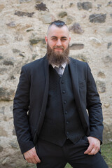 Man with long beard wears a dark elegant suit
