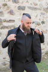 Man with long beard wears a dark elegant suit