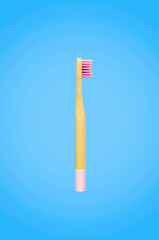 Isolated flat lay style of pink  toothbrush on blue background, pink bamboo toothbrush