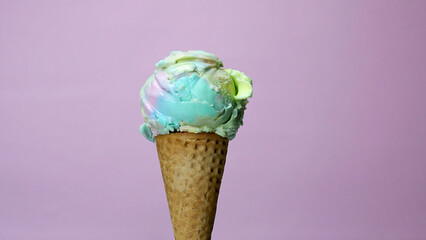 Ice cream Rainbow colorful scoop in waffle cone on pink background, Front view Food concept.