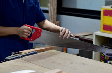 Thai engineer student in carpentry workshop. Spot focus at wood 