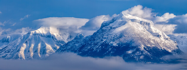 powerful panoramic scene of snow covered mountains above Lake McDonald, Glacier National Park, Montana