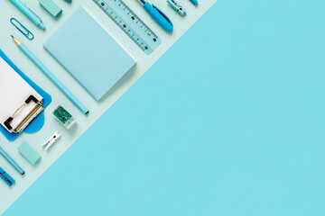 Stationery and office blue monochrome flat lay composition top view. School education concept on...