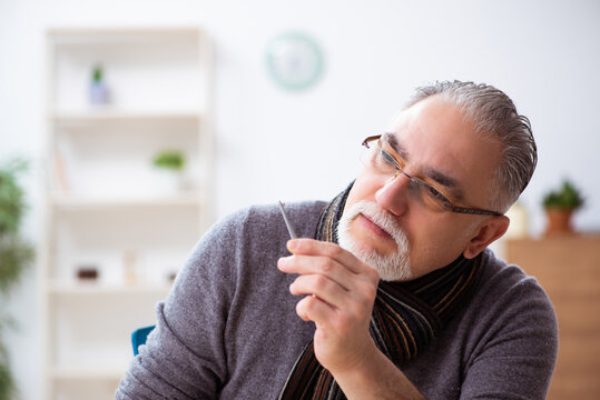 Old male watchmaker working in the workshop