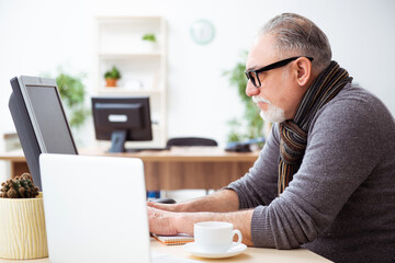 Old male employee working from house during pandemic