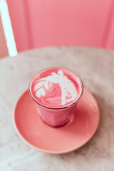 Two trendy beetroot lattes with latte art and flower petals on the foam.