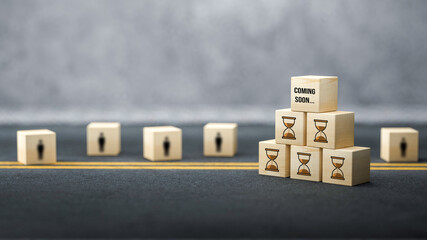 cube with hour glass symbol and message COMING SOON on concrete background