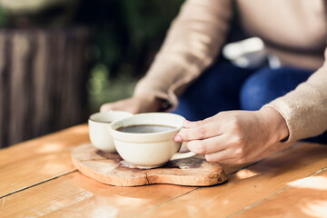 Fototapeta na wymiar Young woman holding a cup of hot coffee in nature view