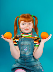 Little girl with the two oranges on an azure background.