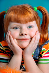 Portrait of the delighted little girl on an azure background.