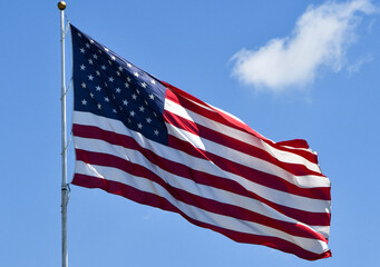 Waving American flag against a blue sky