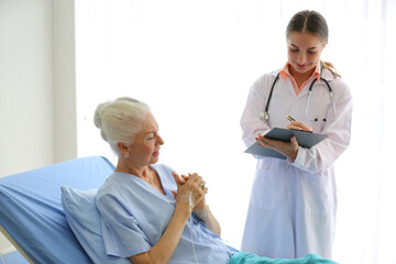 doctor talking to senior patient sitting on a bed in hospital