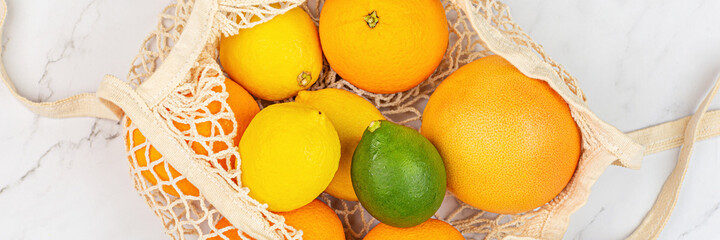 Creative background made of summer tropical fruits with grapefruit, orange, tangerine, lemon, lime on white marble background. Food concept. Flat lay, top view, overhead