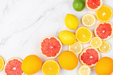 Creative background made of summer tropical fruits with grapefruit, orange, tangerine, lemon, lime on white marble background. Food concept. Flat lay, top view, copy space, mockup
