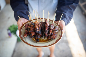 Satay goat satay, lamb, lamb or meat goat satay in grilling place with smoke by people with yummy...