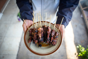 Satay goat satay, lamb, lamb or meat goat satay in grilling place with smoke by people with yummy...