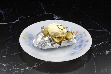 Traditional baked fresh potato with white butter (Shortening) on the plate. Famous side dish with steak menu in restaurant. Popular Appetizer starter menu.