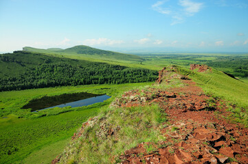 A narrow path going along the top of the mountain to the foot against the backdrop of picturesque...