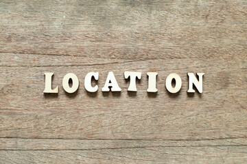 Alphabet letter block in word location on wood background