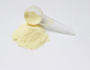 powdered milk and spoon for baby on white background