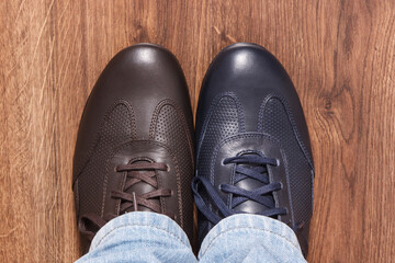 Brown and navy blue shoes for men on rustic board, male footwear concept