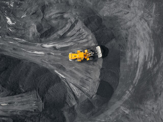 Yellow excavator loads coal Open pit mine, extractive industry, top view aerial