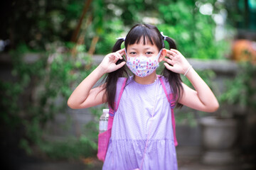 Asian Child wearing face mask going back to school after covid-19 quarantine and lockdown