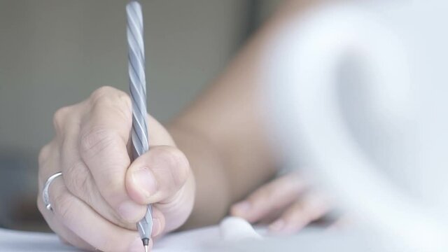 A hand drawing and making sketch with a pen. A jewelry designer makes outlines on paper.