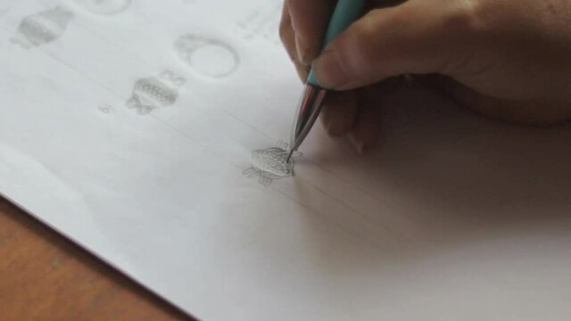 A hand drawing and making sketch with a pen. A jewelry designer makes outlines on paper.