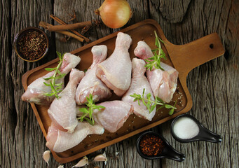 fresh chicken meat with rosemary and spices on wooden board.
