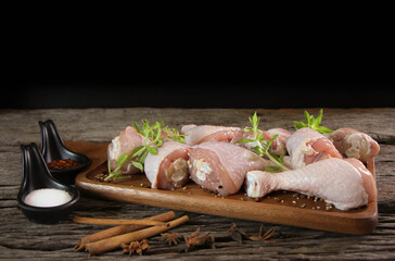 fresh chicken meat with rosemary and spices on wooden board.