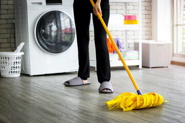 Housewife mopping the floor, woman  using wet-mop while cleaning floor at house
