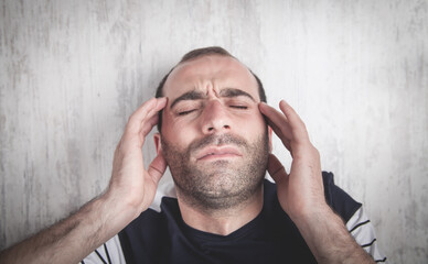 Caucasian man suffering from headache.