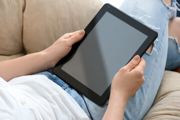 Woman with modern tablet computer at home