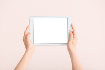 Hands with modern tablet computer on light background