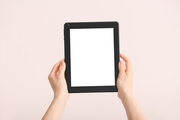 Hands with modern tablet computer on light background
