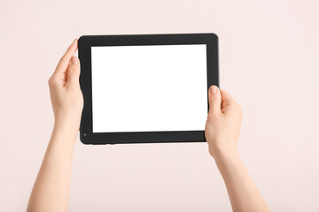 Hands with modern tablet computer on light background