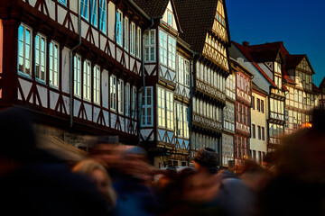 Half-timbered facades over a crowd of people in the evening sun in the old town of Hannover