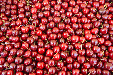 Cherries pile at farmers market, background, texture.