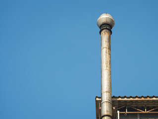 Old chimneys on the roof against the blue sky. Smokestack for smoke out from Industrial building. With space for place your text.