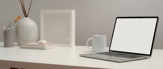 Blank screen laptop on table with stationery and decoration in home office room