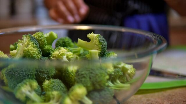 Preparing a bowl of broccoli for a meal or snack - slow motion isolated
