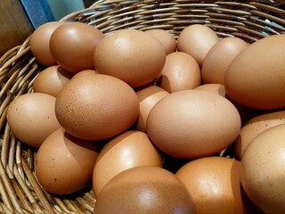 Hen chicken eggs in wood basket .