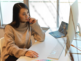 Portrait of female working with computer and office supplies on office desk