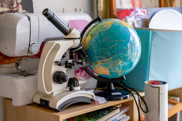 Close-up of household microscope and globe in toy room